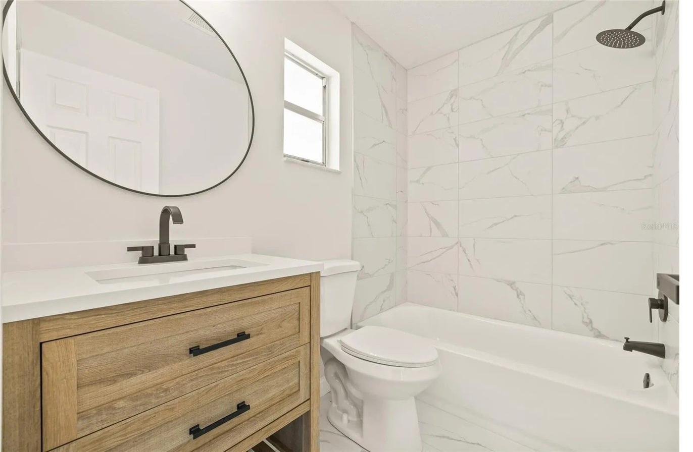 Bathroom vanity remodel with wood cabinets and marble tile — Holiday FL by Carpet Corner Kitchen and Bath
