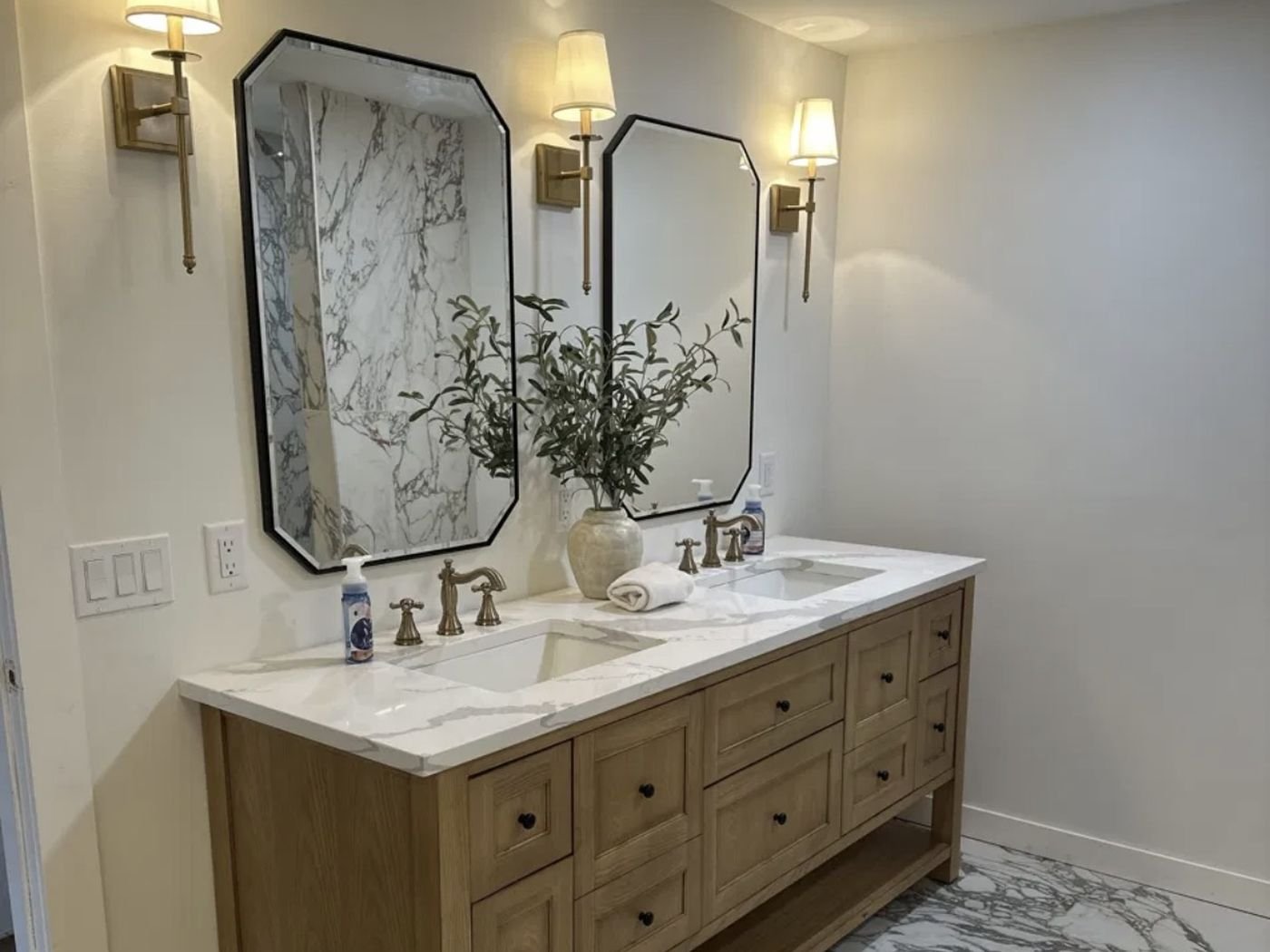 James Martin double-sink oak vanity with octagon mirrors and brass sconces, completed Carpet Corner Kitchen & Bath project, Holiday FL