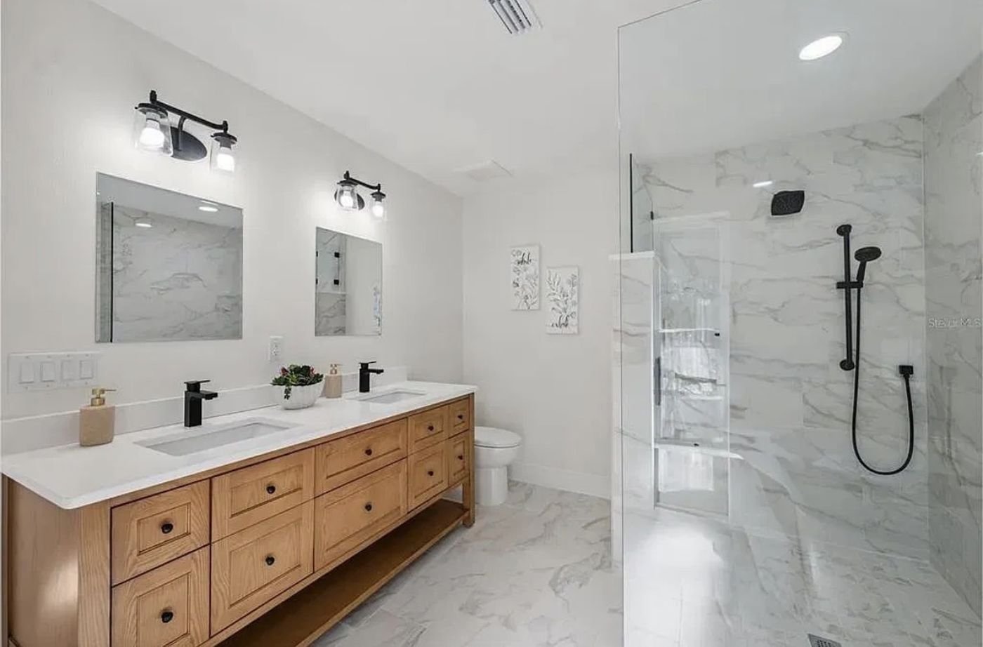 James Martin oak vanity with matte black fixtures and walk-in glass shower, completed Carpet Corner Kitchen & Bath bathroom project, Holiday FL