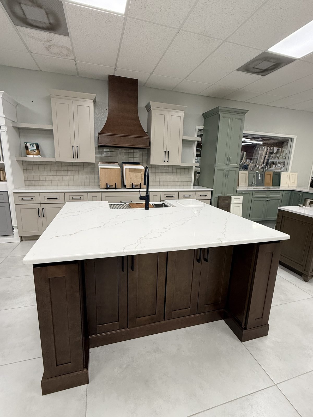 KCD dark stained shaker cabinet island with waterfall quartz countertop on display in Carpet Corner Kitchen & Bath showroom, Holiday FL