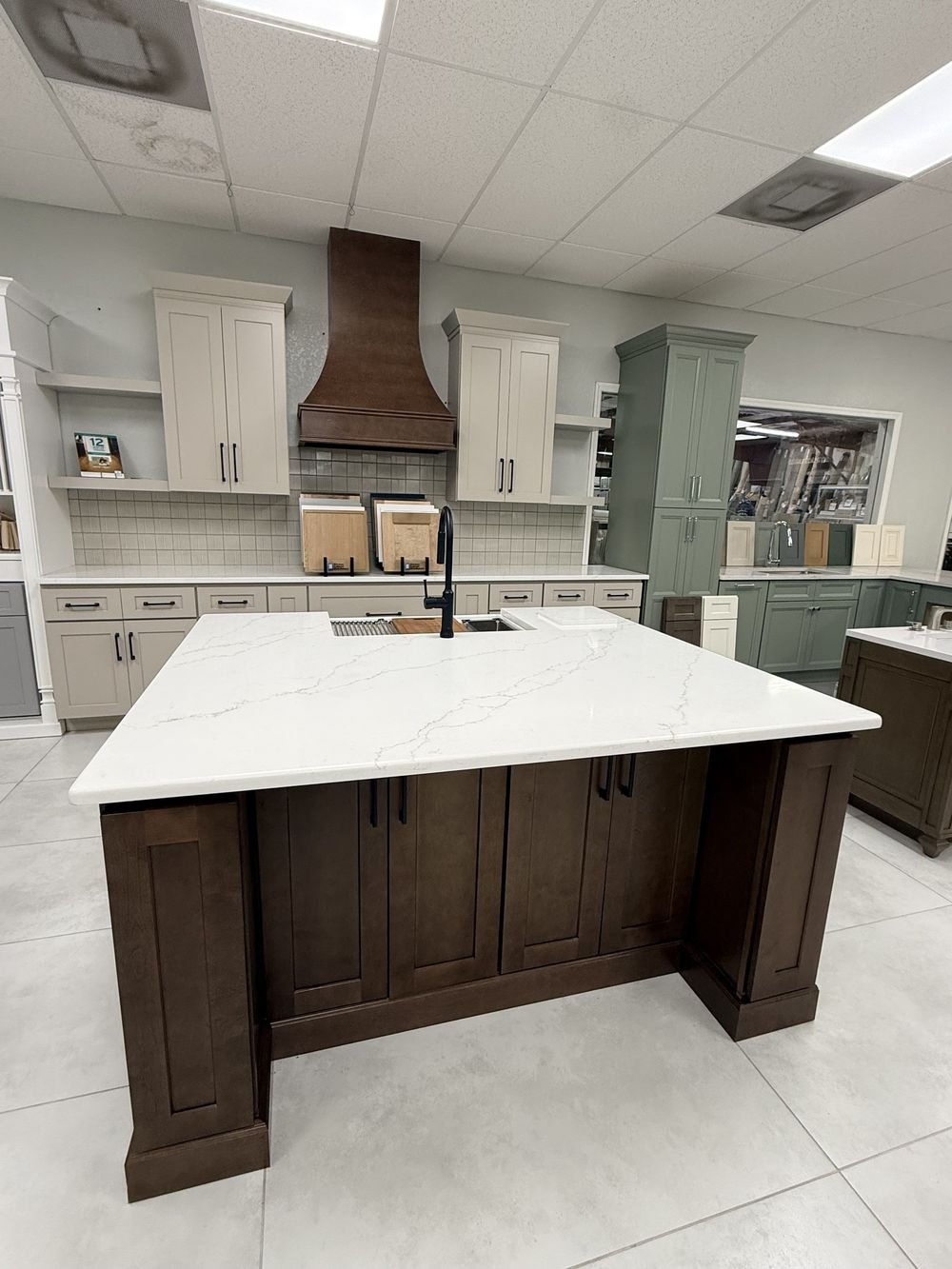 KCD dark stained shaker cabinet island with waterfall quartz countertop on display in Carpet Corner Kitchen & Bath showroom, Holiday FL
