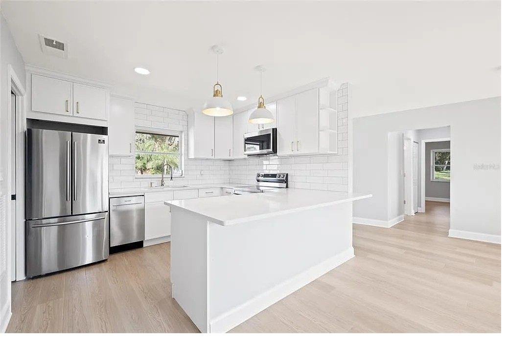 White kitchen cabinets with large island installed near Land O Lakes FL by Carpet Corner Kitchen and Bath