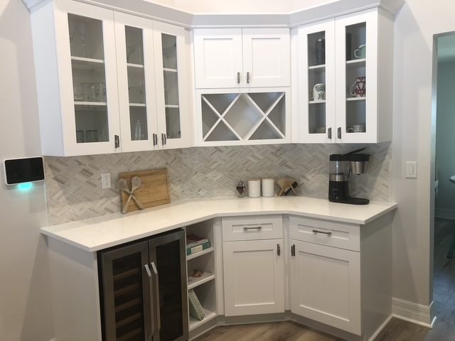 Wet bar white cabinets wine fridge herringbone backsplash Holiday FL